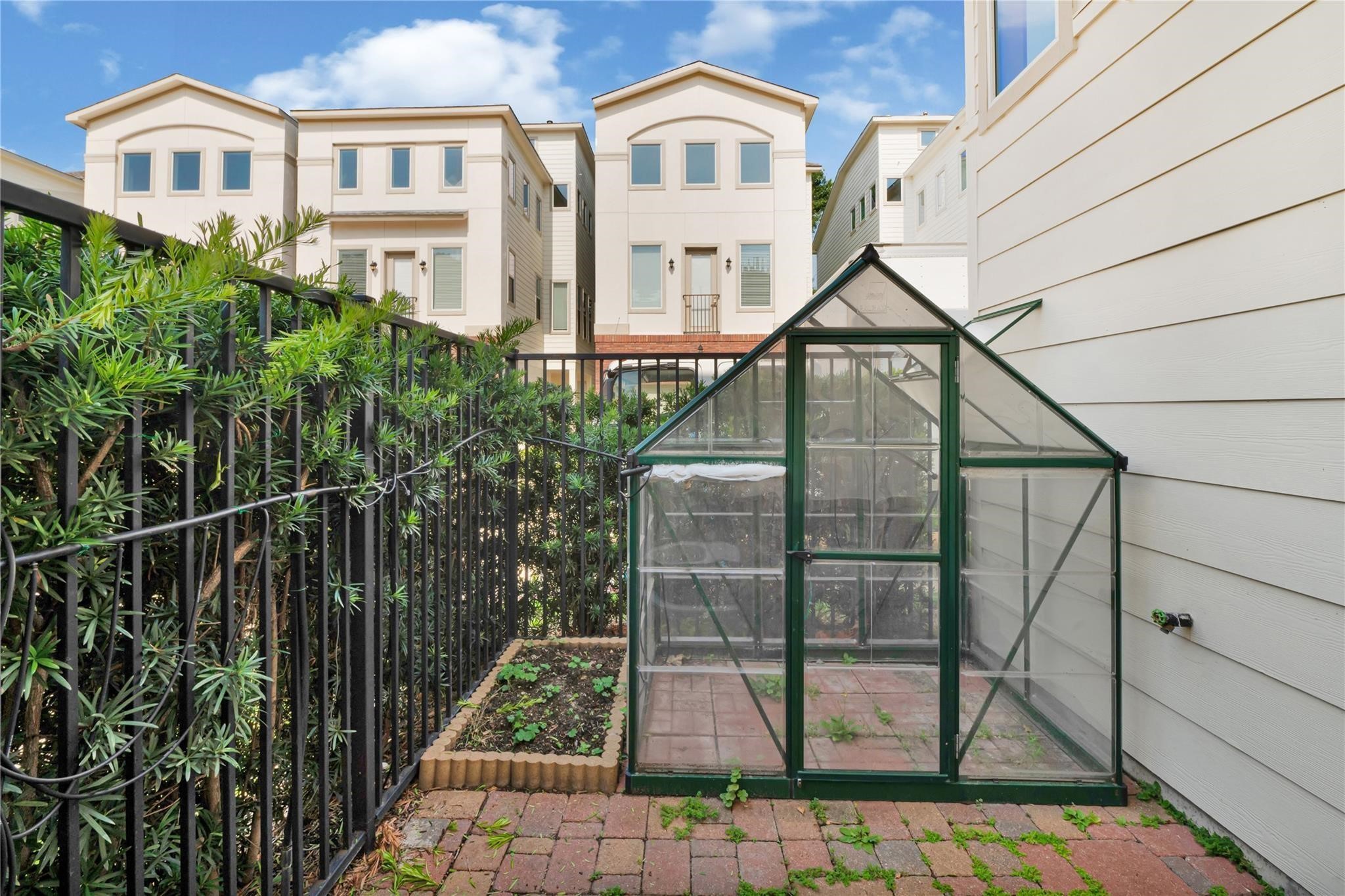 1210 Cedarpost Tree Springs Place, Unit P Houston, TX 77055 - Photo 25 of 25 a view of a brick house with large windows and a small yard