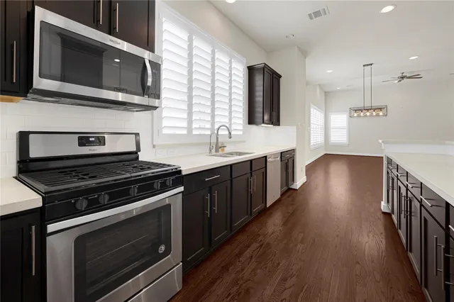 a kitchen with wooden floor and steel stainless steel appliances