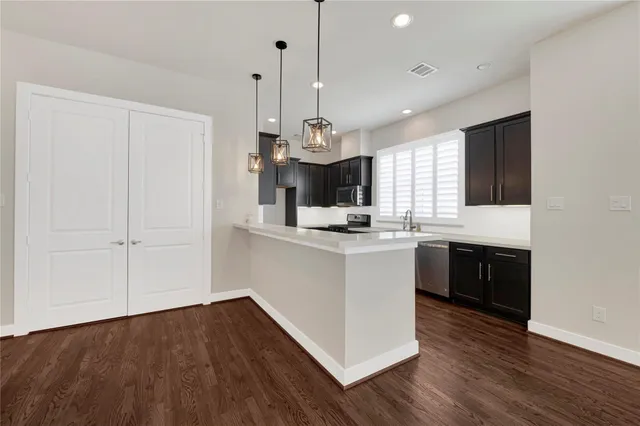 a kitchen with kitchen island granite countertop wooden floors and white cabinets
