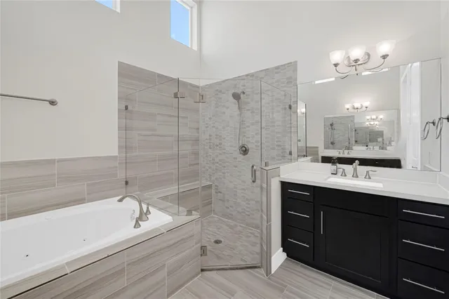 a bathroom with a bathtub sink double vanity and mirror