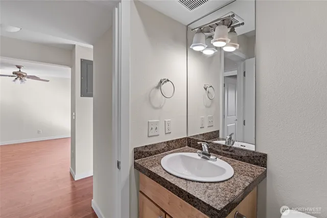 a bathroom with a granite countertop sink a mirror and shower