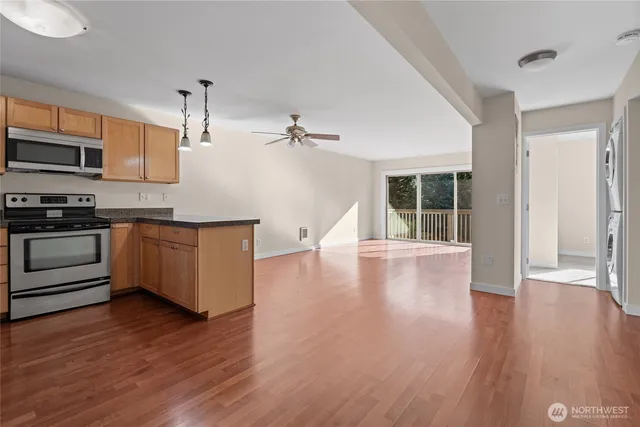 a kitchen with stainless steel appliances wooden floors and view living room