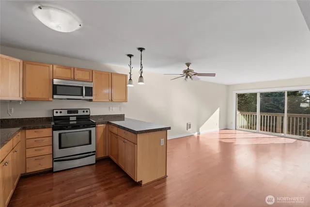 a kitchen with stainless steel appliances granite countertop a stove a sink and a microwave