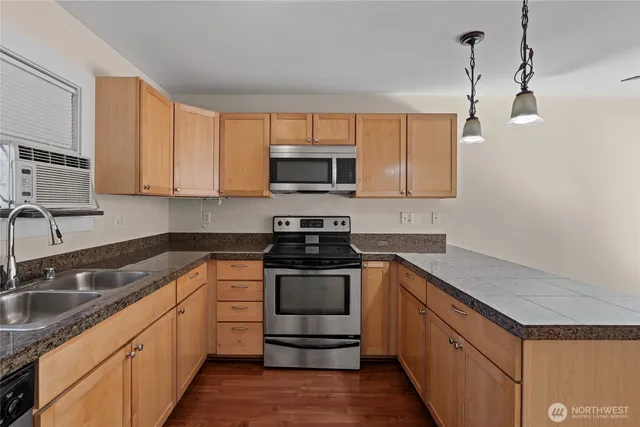 a kitchen with stainless steel appliances granite countertop a sink stove and microwave