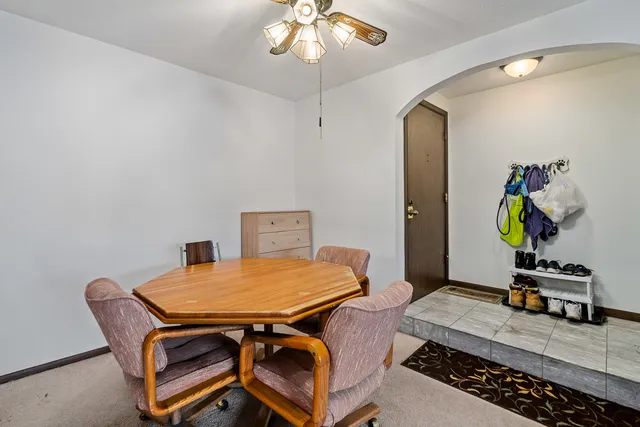 a room with a table and ceiling fan
