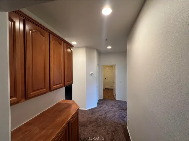 a view of hallway with closet and wooden floor