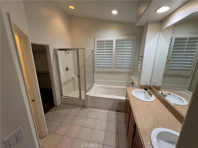 a bathroom with a tub a sink and a large mirror