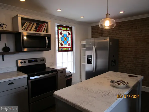 a kitchen with a refrigerator and a flat screen tv