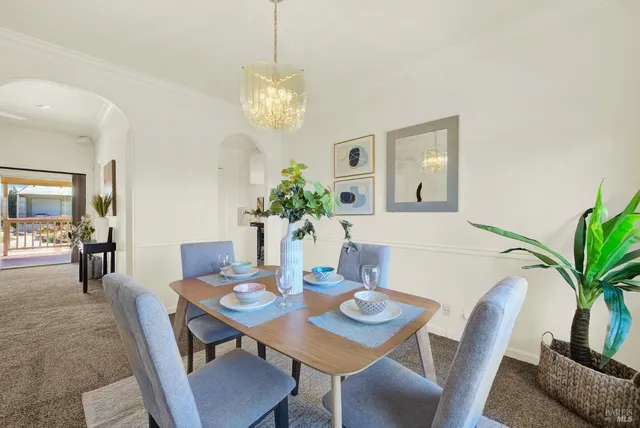 a living room with furniture flowerpot and a chandelier