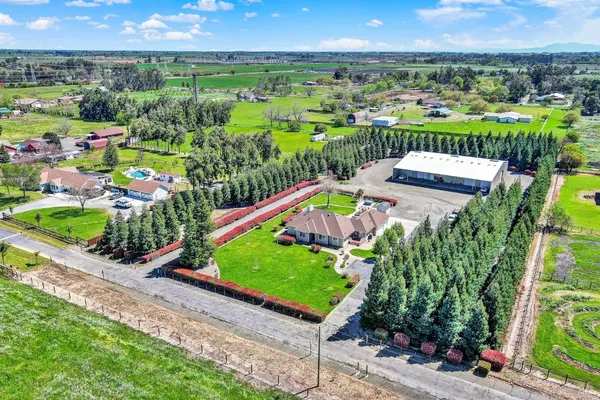 a view of a white house with a big yard and a large tree