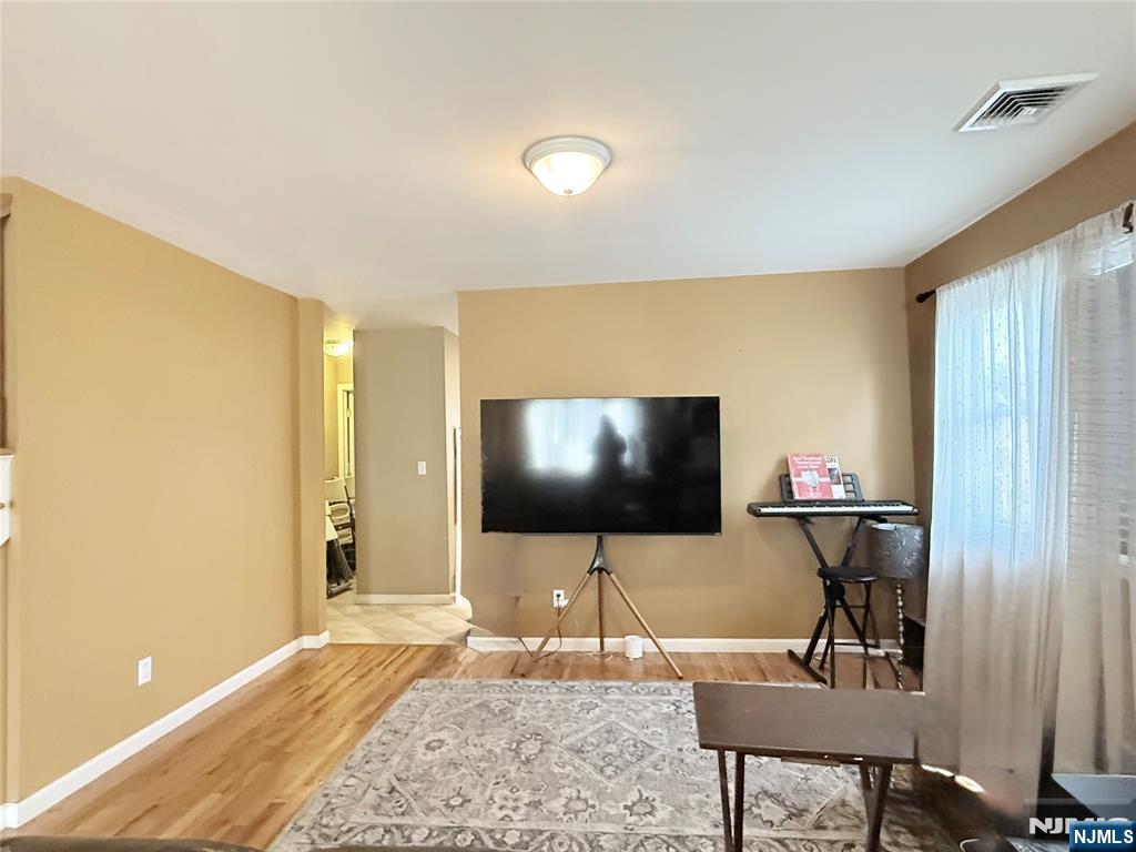 58 River Street, Unit B Lodi, NJ 07644 - Photo 4 of 11 a living room with table and flat screen tv