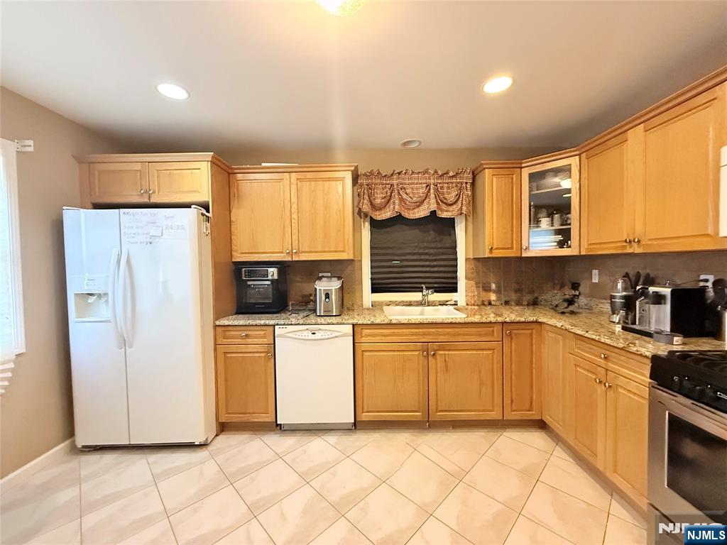 58 River Street, Unit B Lodi, NJ 07644 - Photo 7 of 11 a kitchen with stainless steel appliances granite countertop a stove a sink and a refrigerator