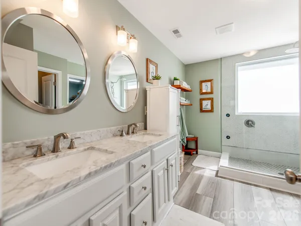 a en suite bathroom with a double vanity sink and a mirror