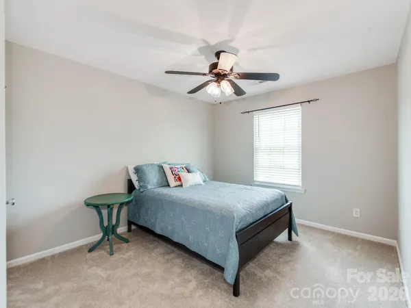 a bedroom with a bed and a ceiling fan