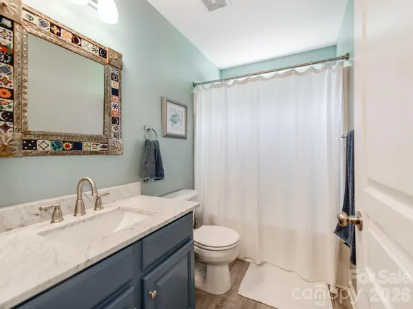 a bathroom with a granite countertop sink toilet and shower