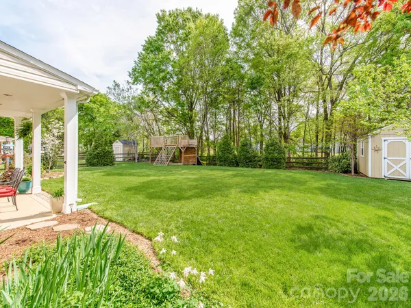 a view of a backyard with a garden and trees