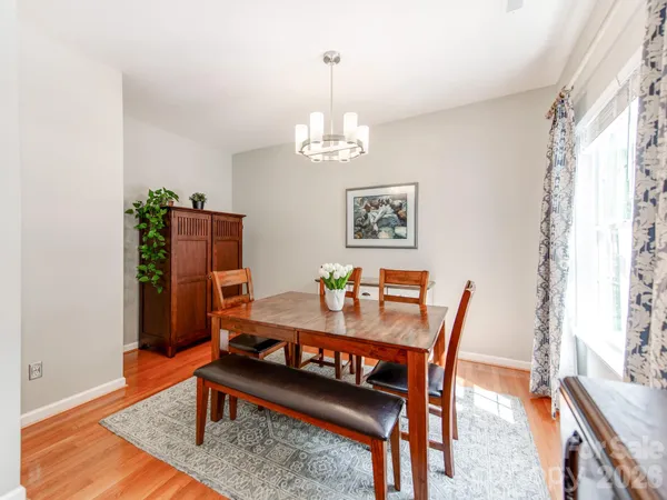 a view of a dining room with furniture a chandelier and wooden floor