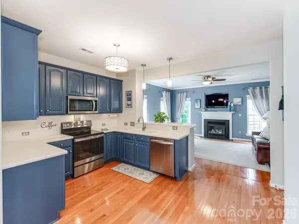 a large kitchen with stainless steel appliances granite countertop a stove and cabinets