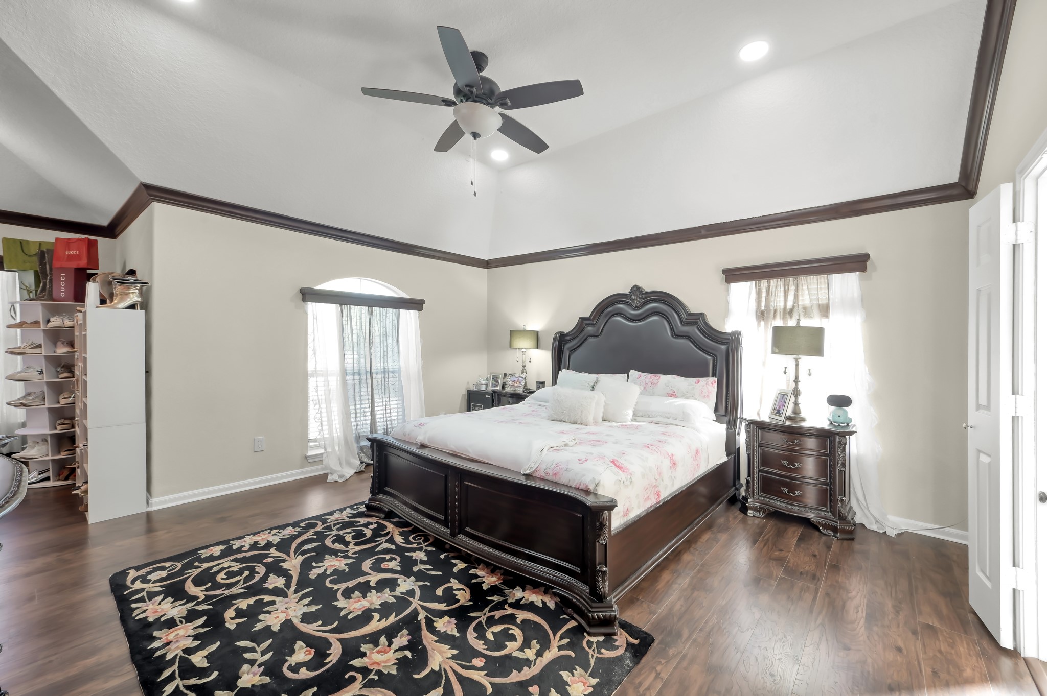 1000 Arbor Way Conroe, TX 77303 - Photo 14 of 29 This spacious primary bedroom features high ceilings with a ceiling fan and luxury vinyl plan floors. Natural light streams through two windows.