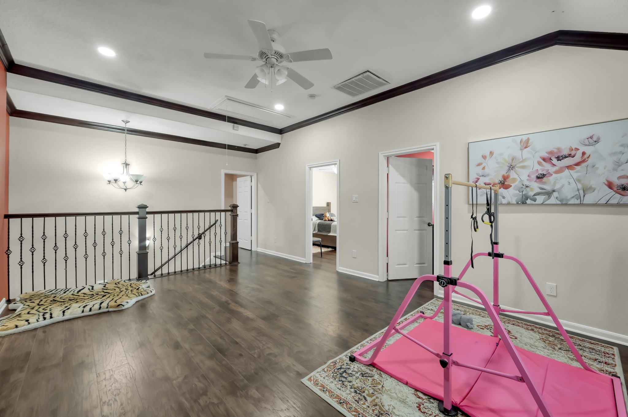 1000 Arbor Way Conroe, TX 77303 - Photo 21 of 29 This spacious, open game room area features elegant flooring and a stylish iron railing with a view to the lower level. A modern ceiling fan and recessed lighting enhances the room.