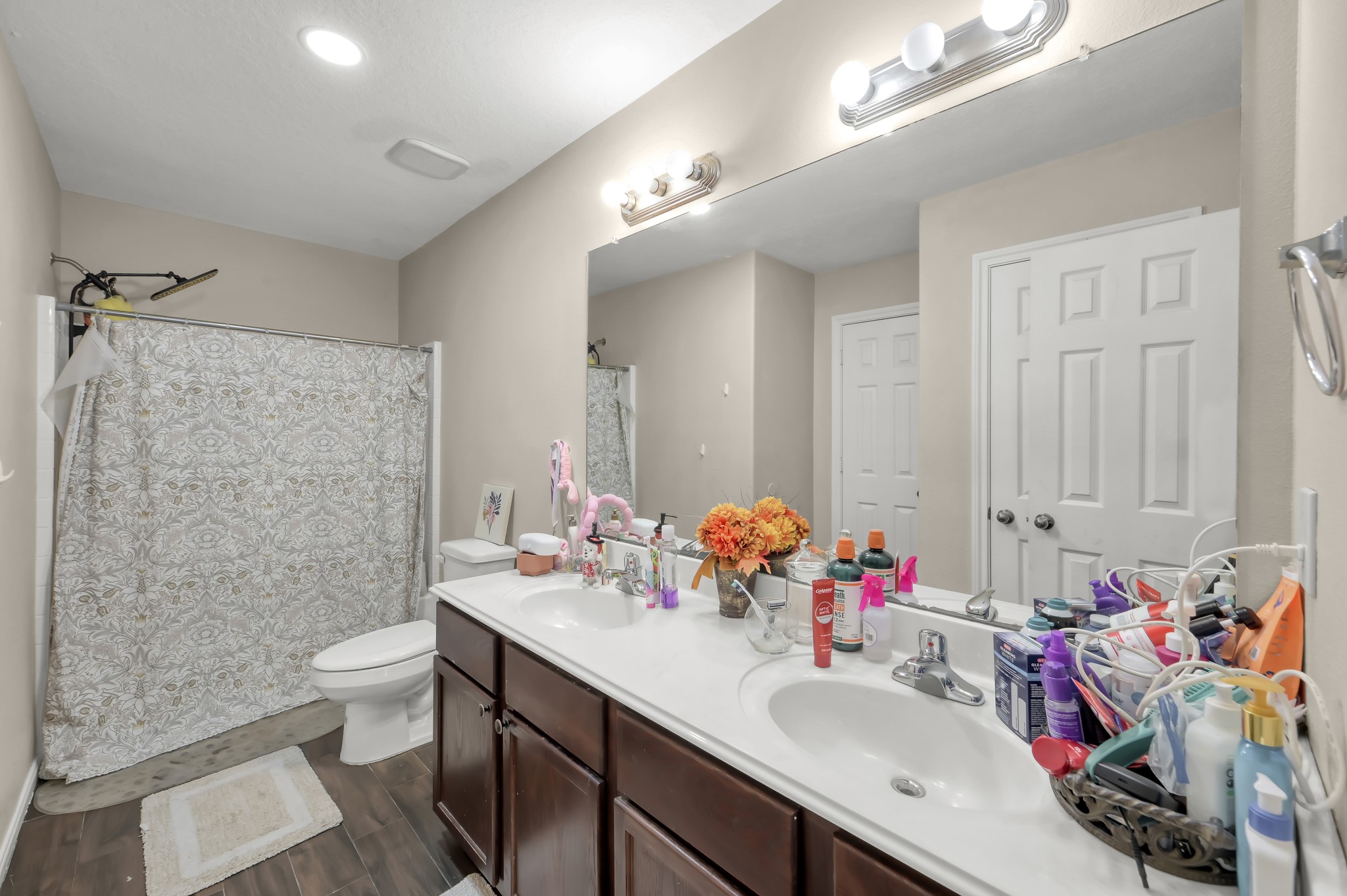 1000 Arbor Way Conroe, TX 77303 - Photo 23 of 29 This bathroom features a dual-sink vanity with ample storage, a large mirror, and a shower-tub combo. The neutral color palette and modern lighting create a bright, welcoming space.