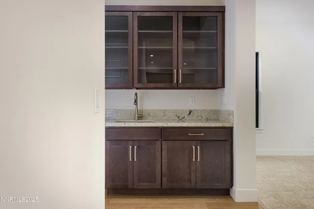 a view of an empty room with a kitchen and a window