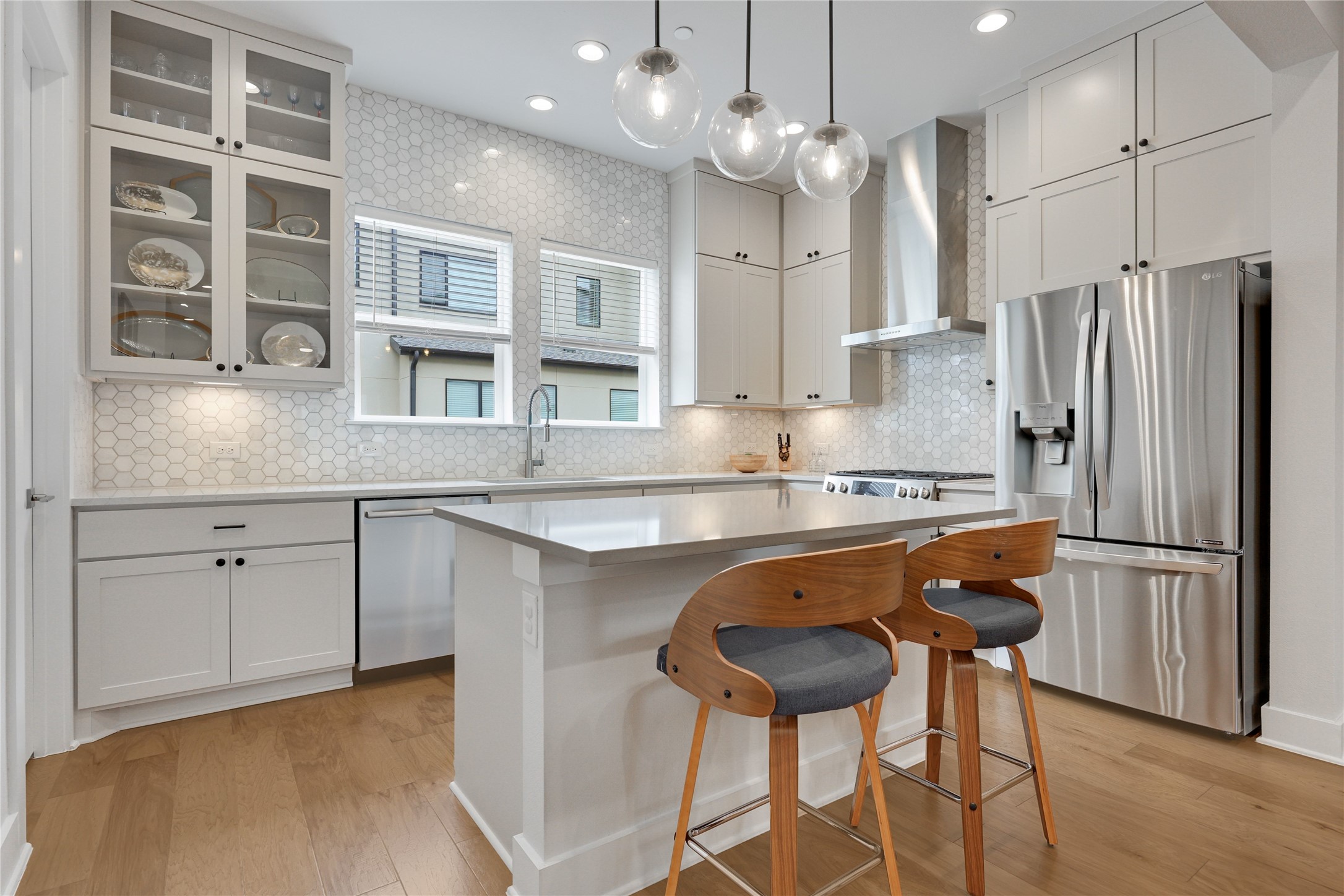 3904 Sightline Street, Unit 125 Austin, TX 78731 - Photo 17 of 37 a kitchen with stainless steel appliances granite countertop a sink a stove a refrigerator and island with wooden floor
