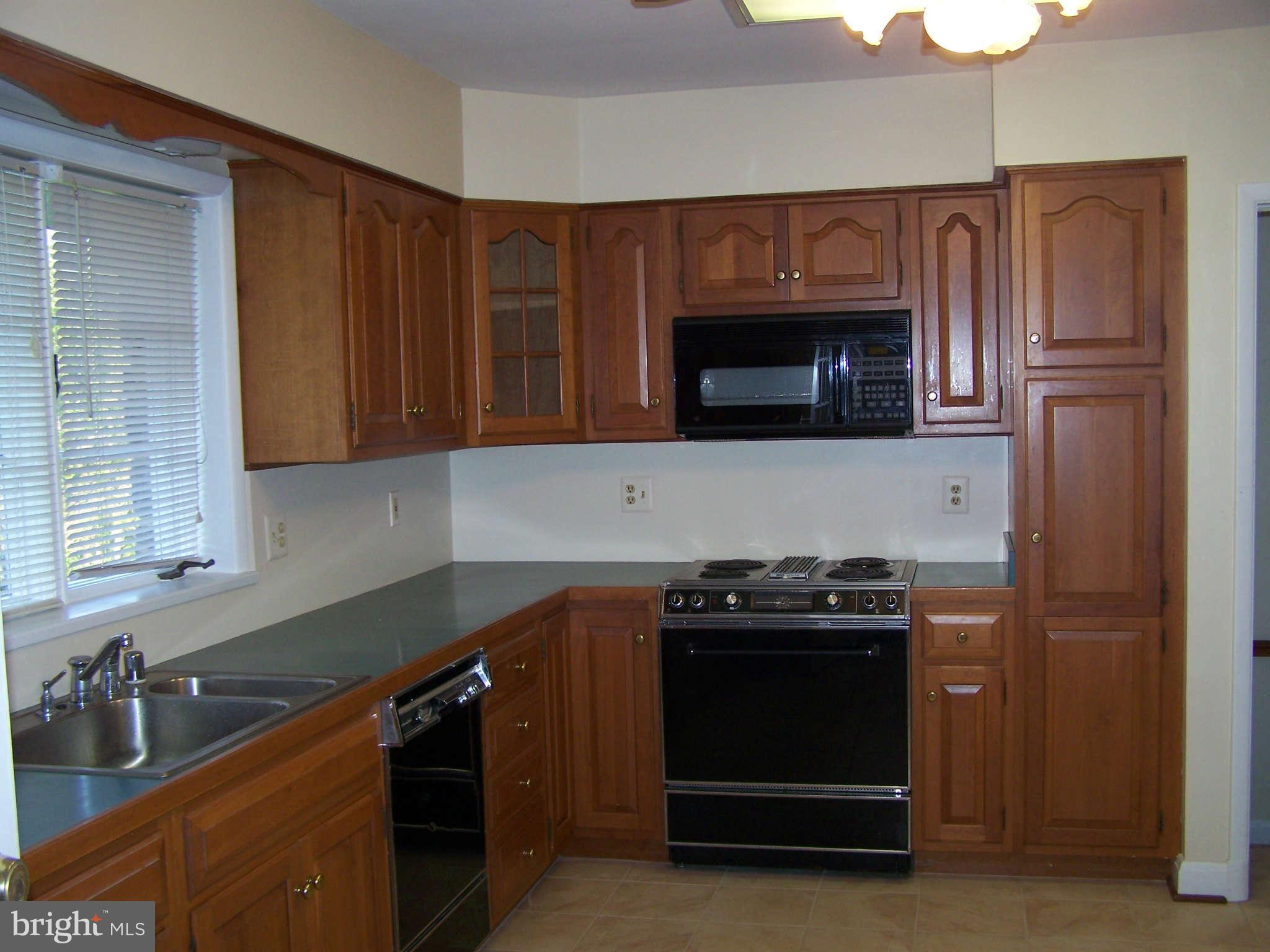 3117 Rices Lane Baltimore, MD 21244 - Photo 8 of 23 a kitchen with stainless steel appliances a stove a microwave cabinets and a sink