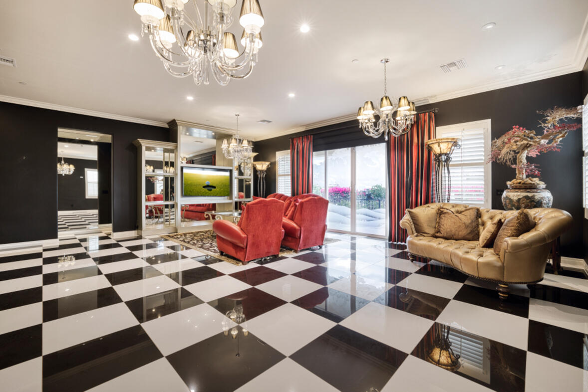 a living room with a black white checkered floor with couches chair and a coffee table