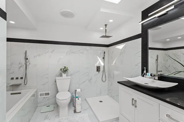 a bathroom with a sink a toilet and shower