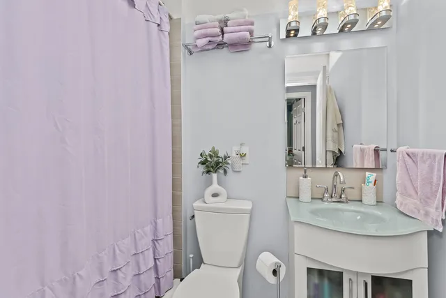 a bathroom with a granite countertop sink a toilet and a mirror