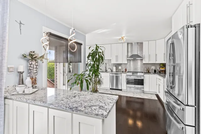 a kitchen with stainless steel appliances granite countertop a sink stove and refrigerator