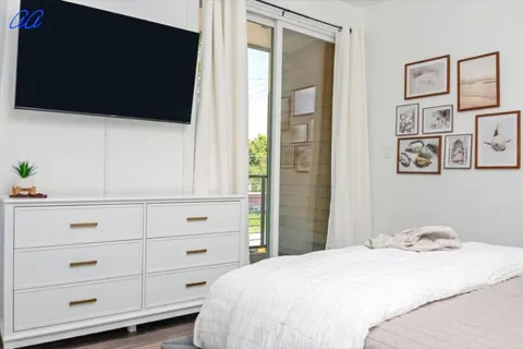 a bedroom with a bed and a flat tv screen on the dresser