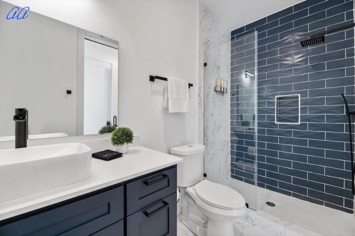 5401 Stuart Circle, Unit 1 Austin, TX 78721 - Photo 20 of 24 a bathroom with a sink a toilet and shower