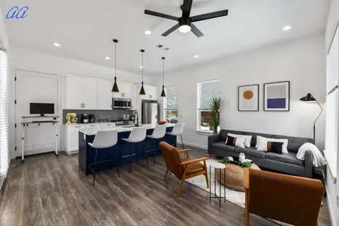 a living room with furniture kitchen view and a window