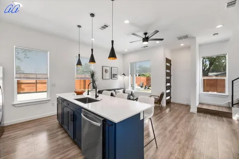 a kitchen with a stove a sink a window and chairs