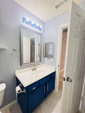 a bathroom with a sink vanity and mirror