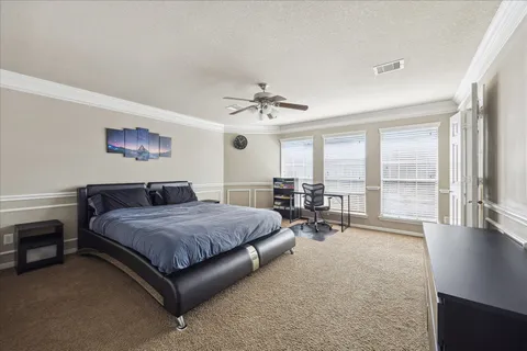 a spacious bedroom with a bed and large windows