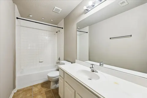 a bathroom with a bathtub shower sink mirror and toilet