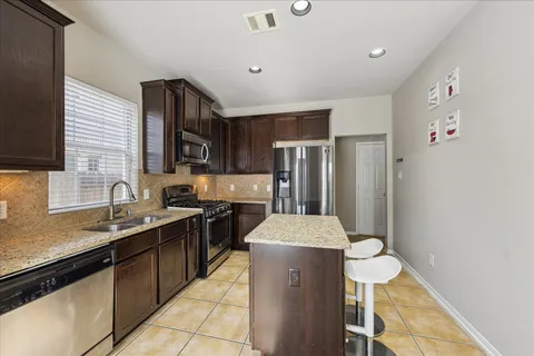 a kitchen with stainless steel appliances a sink stove and refrigerator