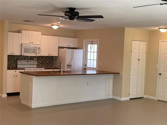 a kitchen with stainless steel appliances a sink a stove a refrigerator cabinets and a window