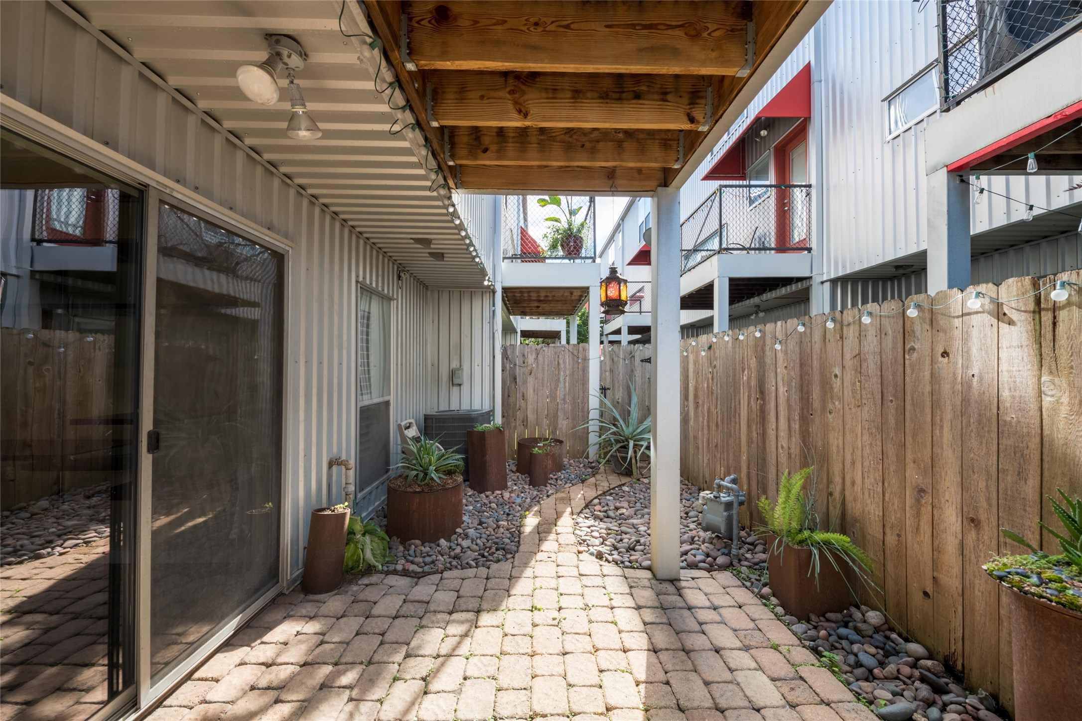 807 Robin Street Houston, TX 77019 - Photo 7 of 46 Enjoy outdoor space without the yardwork in the fully-fenced, easy-care yard featuring a paver patio, river rock and plantings.