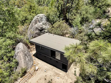 an aerial view of a house with a yard and large trees