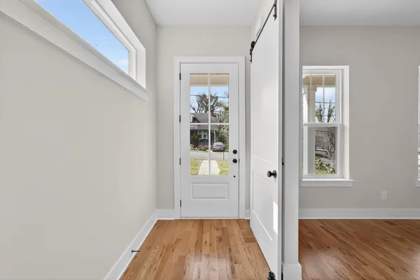 a view of a hallway with wooden floor and a window
