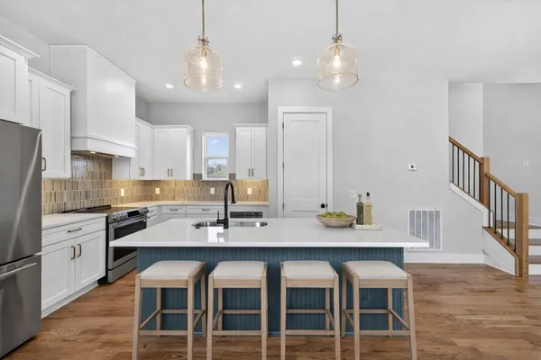 a kitchen with kitchen island a sink stainless steel appliances and cabinets