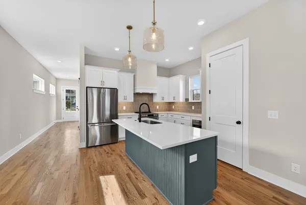 a kitchen with a sink and a stove with wooden floor