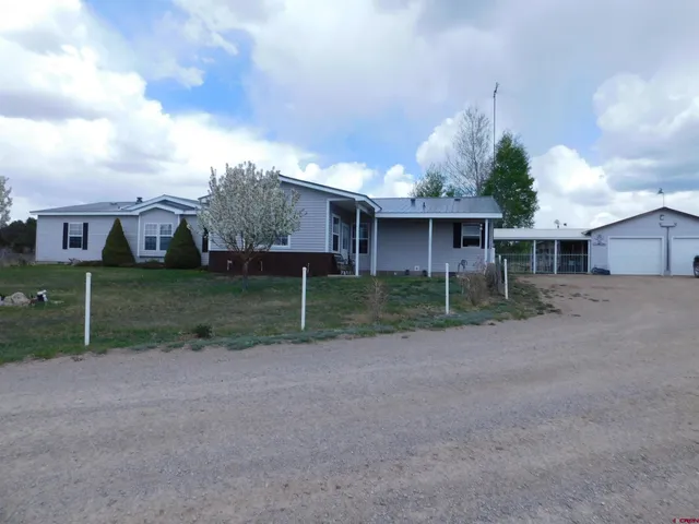a view of a small house in middle of the green field