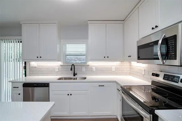 a kitchen with a sink stainless steel appliances and cabinets