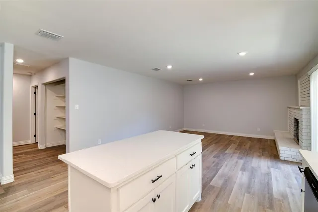 a kitchen with a wooden floor and white walls