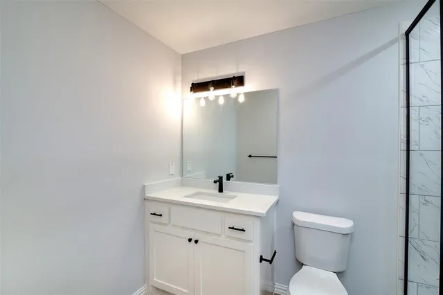 a bathroom with a toilet a sink and mirror